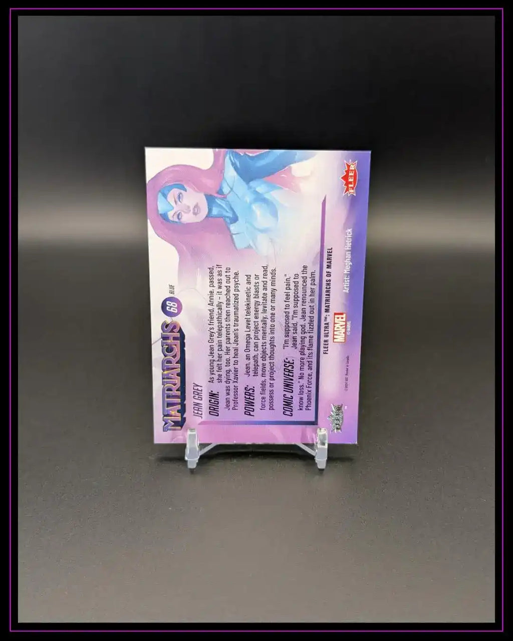 Rückseite einer Trading Card mit Comic-Charakter, lila Hintergrund, Sammelkarte auf Ständer