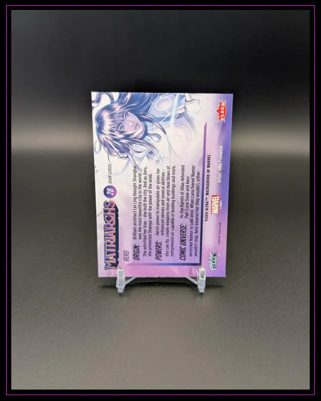 Rückseite einer lila Marvel Trading Card mit weiblicher Comicfigur, auf Ständer vor schwarzem Hintergrund