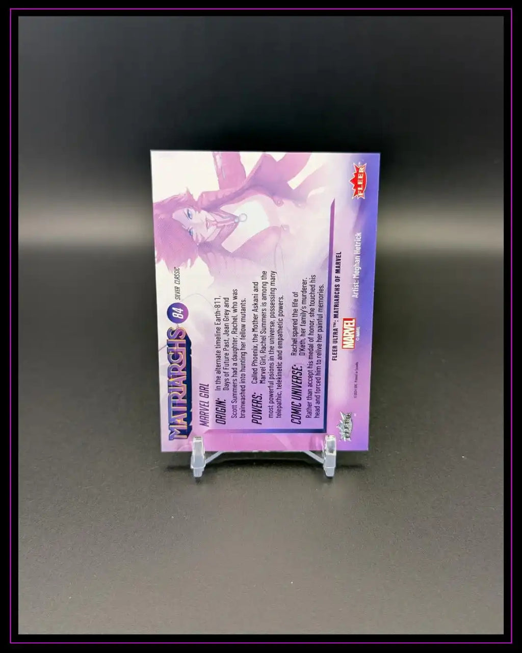 Rückseite einer lila Marvel Trading Card mit Text und Comicfigur, auf Kartenhalter.