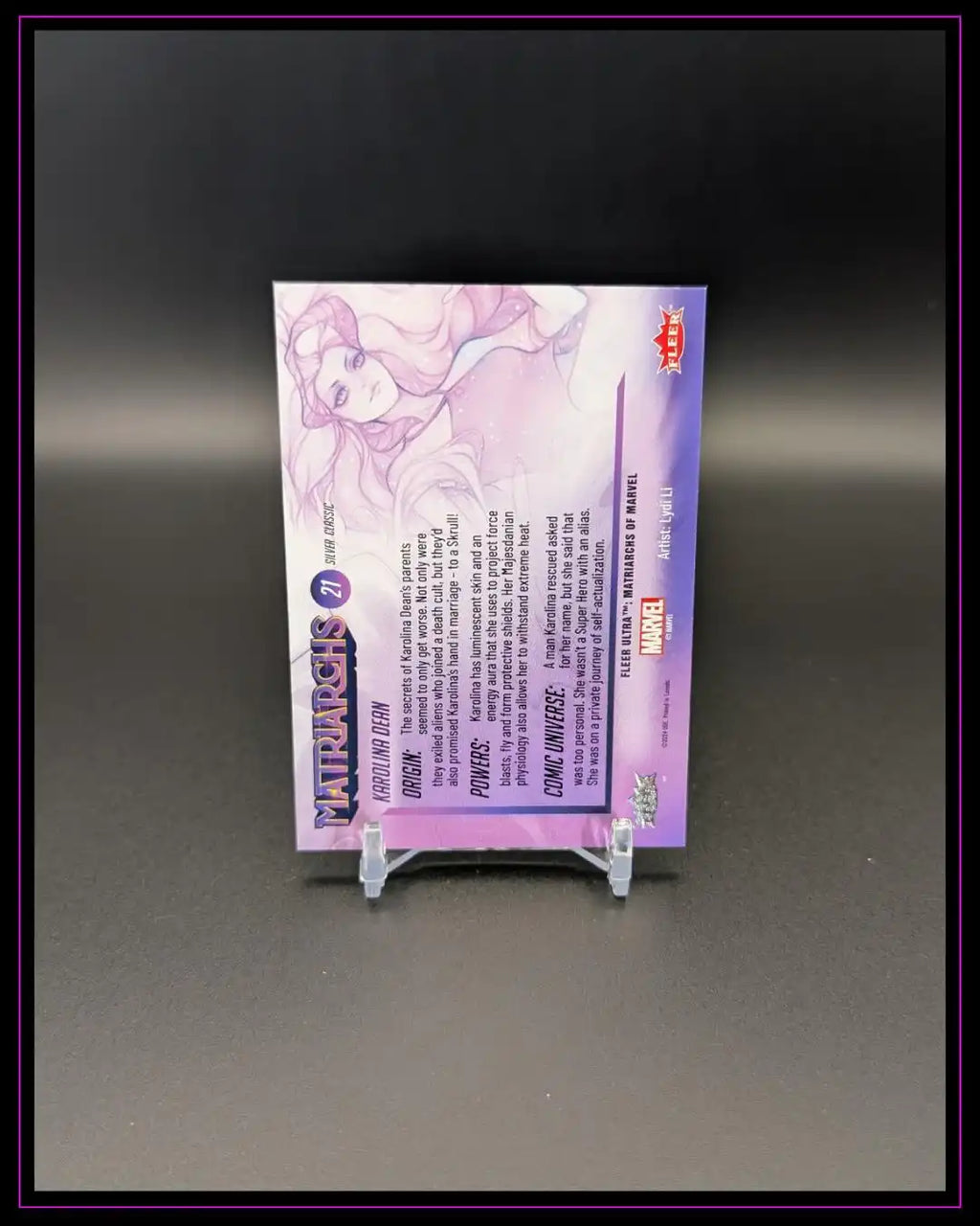 Rückseite einer Trading Card mit lila Design, Text und Comicfigur Illustration, auf Kartenständer