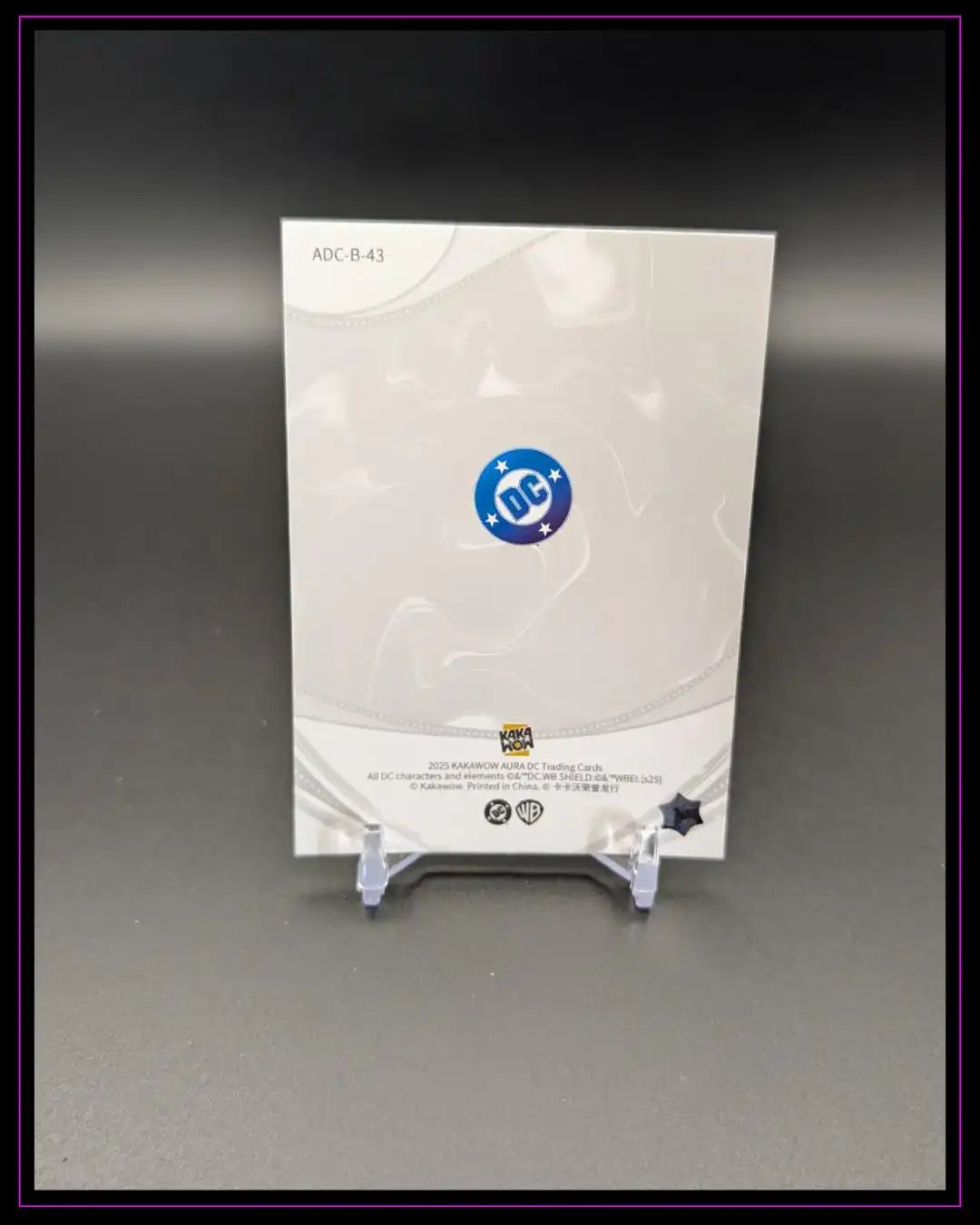 Rückseite einer DC Trading Card auf Displayständer, Kakawow Aura 2023, grauer Hintergrund