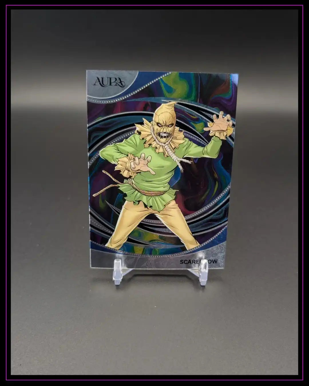 Trading Card mit bunter Aura, Comicfigur Scarecrow im Vordergrund, Sammlerkarte auf Ständer
