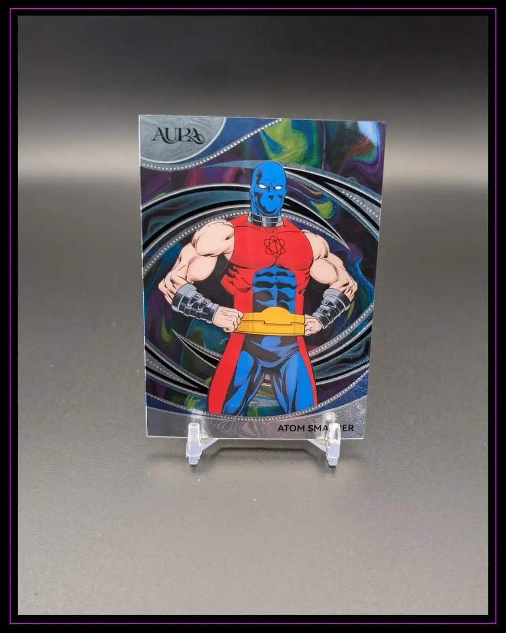 Sammelkarte mit Comic-Superheld Atom Smasher vor buntem Hintergrund, Trading Card auf Ständer