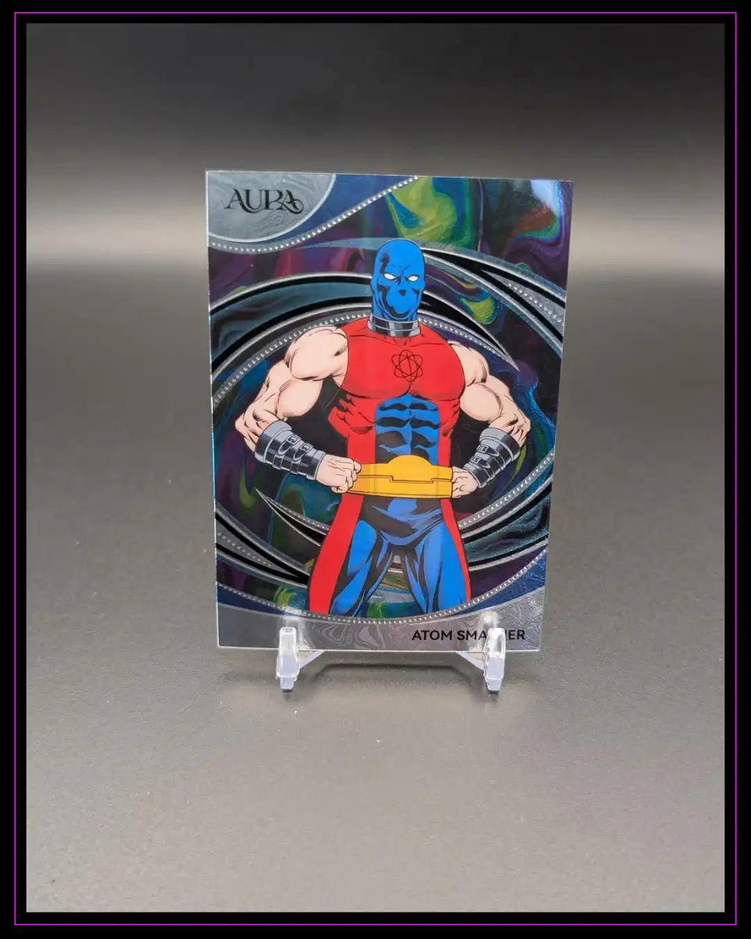 Sammelkarte mit Comic-Superheld Atom Smasher vor buntem Hintergrund, Trading Card auf Ständer