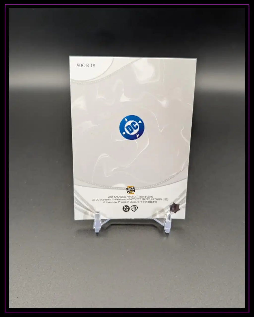 Rückseite einer DC Trading Card mit Logo, auf Kartenständer vor schwarzem Hintergrund