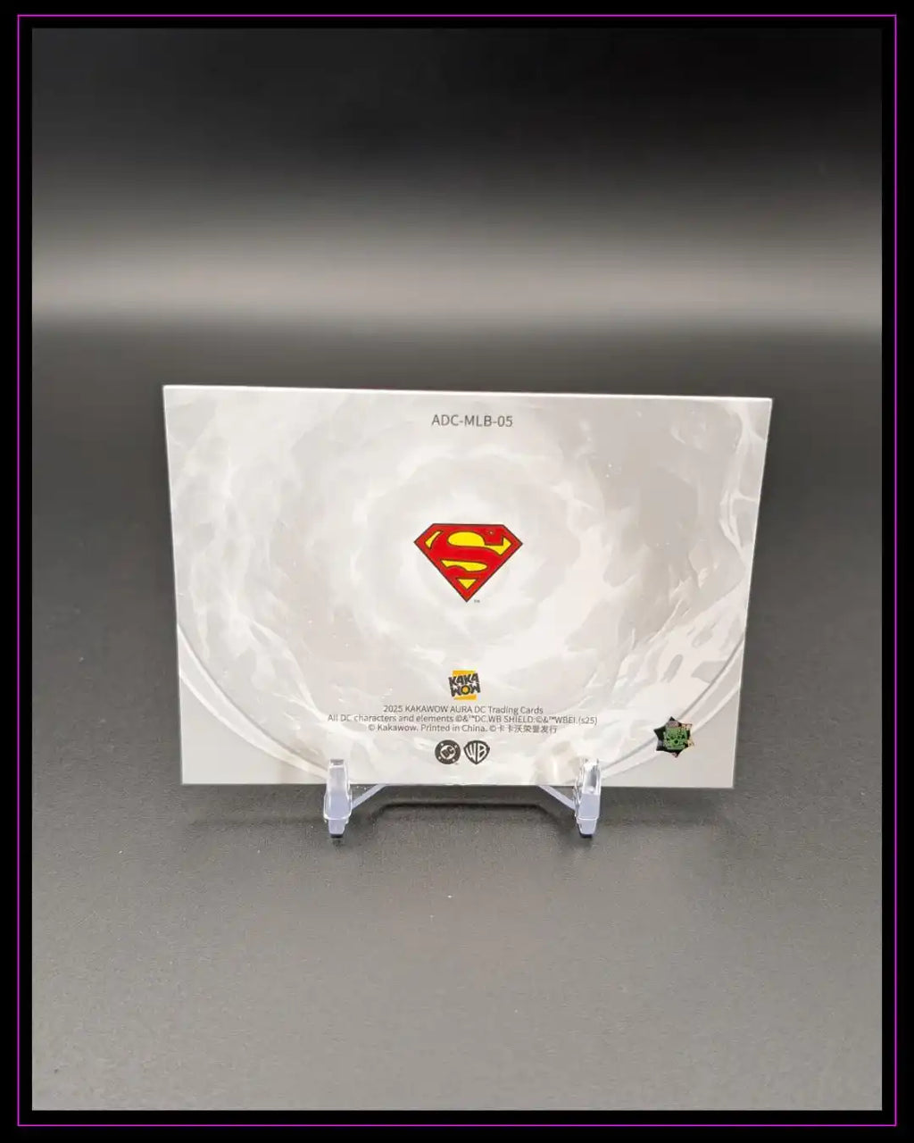 Rückseite einer DC Trading Card mit Superman-Logo auf Kartenhalter, neutrale Hintergrundfarbe.
