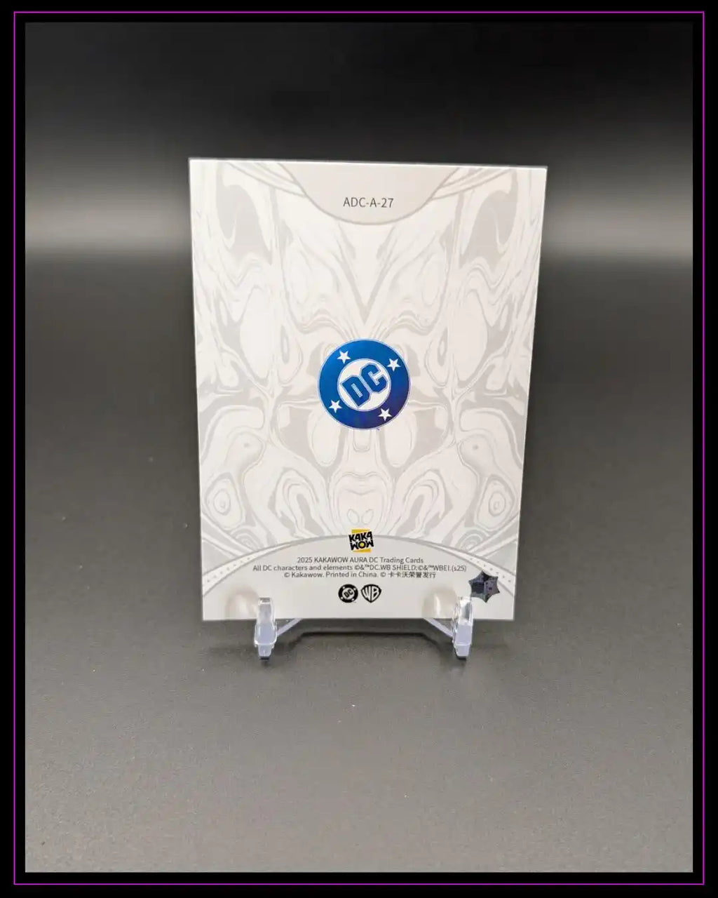 Rückseite einer DC Trading Card auf Kartenständer mit stilisiertem Muster und DC-Logo
