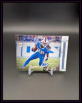 Football Trading Card mit Spieler im blauen Trikot, Rookie Card, auf Ständer vor schwarzem Hintergrund