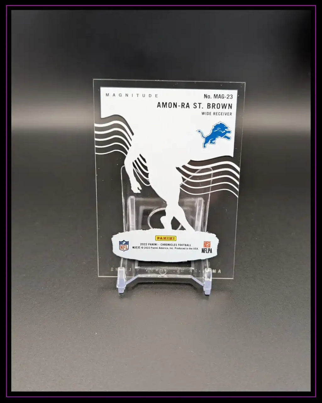 Panini NFL Trading Card Amon-Ra St. Brown, Wide Receiver, auf Kartenhalter vor schwarzem Hintergrund