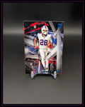 Football Trading Card mit Spieler in weißer Uniform, dynamischer Hintergrund, RC-Logo oben rechts.
