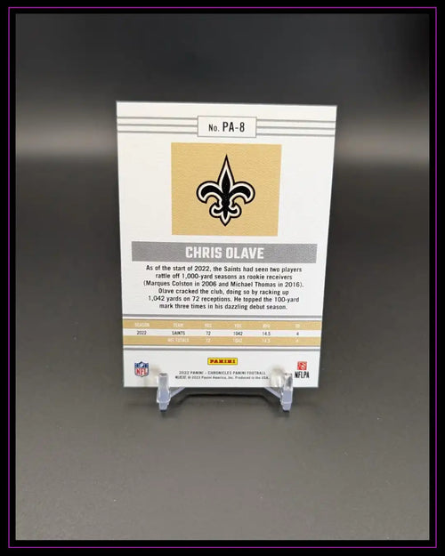Rückseite einer NFL Chris Olave Trading Card auf Ständer, Statistiken und Saints-Logo sichtbar